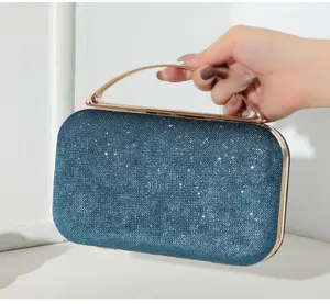 Detailansicht der blauen Glitzertextur und des Goldgriffs dieser eleganten Abend-Clutch.