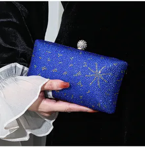 Detailansicht einer königsblauen Strass-Abendtasche mit funkelnden goldenen Sternen.