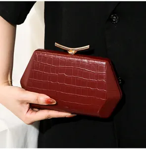 Nahaufnahme der weinroten Abend-Clutch mit Krokoprägung und elegantem Goldverschluss