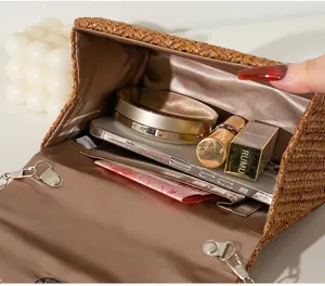 Detaillierte Innenansicht der Lagerkapazität einer braun gewebten Abendhandtasche