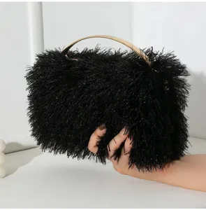 Nahaufnahme der schwarzen Feder-Box-Clutch mit elegantem goldenem Griff