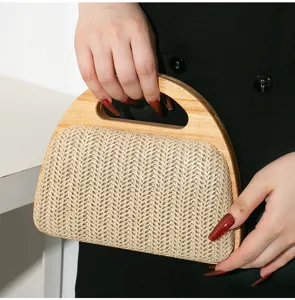 Detailansicht einer eleganten Stroh-Handtasche mit einem Griff aus natürlichem Echtholz