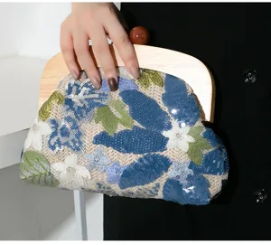 Close-up of elegant sequin floral embroidery on a straw woven clutch with wood handle
