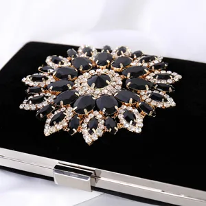 Elegant black velvet evening clutch bag with a large rhinestone sunflower decoration.