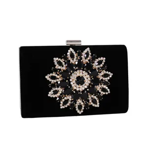 Elegant black velvet clutch bag with sunflower rhinestone pattern on a white background.