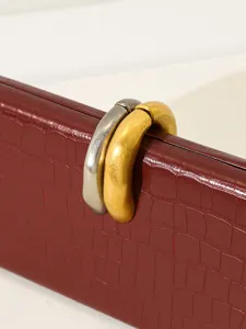 Bolso de noche elegante color burdeos con patrón de cocodrilo y cierre metálico único