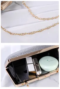 Makroansicht des Innenraums und der eleganten goldenen Kette der silbernen Abendtasche.