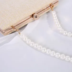 Detailopname van een elegante goud geweven avondtas met een luxe parelketting