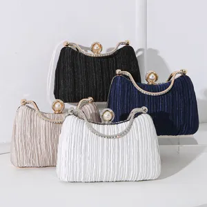 Detailansicht eleganter plissierter Abend-Clutches mit Perlen- und Strassverschlüssen