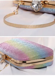 Nahaufnahme einer glitzernden Abendtasche mit Kristallverschluss und Goldgriff.