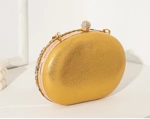 Détail d'une pochette de soirée dorée ovale avec strass colorés et fermoir en diamant