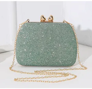 Nahaufnahme der grünen Glitzer-Abendtasche mit ihrem elegantem Goldherzverschluss