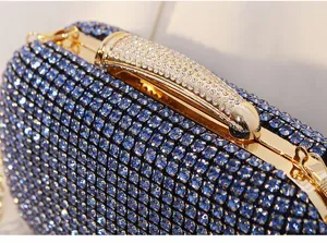 Nahaufnahme glitzernder blauer Strasssteine auf einer luxuriösen Abendtasche mit Goldrahmen