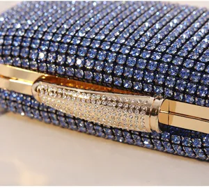 Nahaufnahme einer blauen Abendtasche mit Strasssteinen und funkelndem Goldverschluss