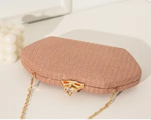 Nahaufnahme des eleganten Kristallverschlusses der schimmernden rosa gewebten Abendtasche