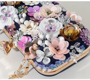 Detalle de los adornos florales 3D hechos a mano en un bolso de mano de fiesta lujoso