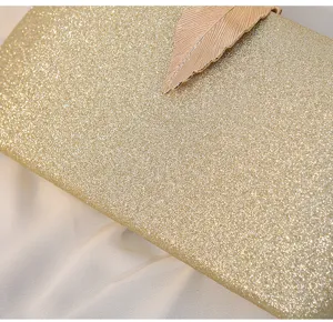 Close-up detail of luxury gold glitter evening clutch bag with elegant metallic leaf clasp