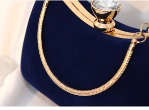 Detailansicht einer Samt-Abendtasche mit Kristallverschluss und goldener Schlangenkette