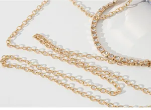 Makrodetail der goldenen Kette und des Strassriemens der eleganten Abend-Clutch.