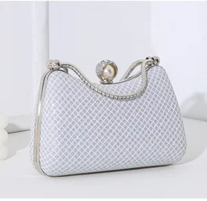 Detailansicht der eleganten Perlen- und Strassschließe an der silbernen Gittertasche
