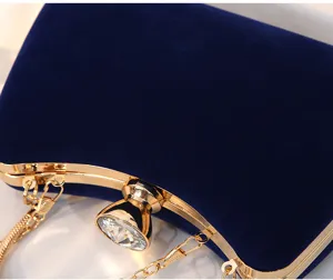 Detail eines eleganten dunkelblauen Samt-Abendtasche mit Kristallverschluss und Gold