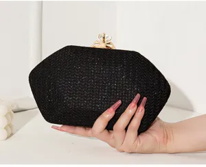 Detailaufnahme einer eleganten schwarzen Abendtasche mit Kristallverschluss und feiner Textur