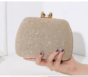 Nahaufnahme einer funkelnden goldenen Abendtasche mit herzförmigen Verschlüssen
