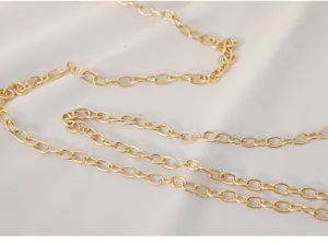 Close-up detail of a glossy gold metal chain strap for an elegant evening clutch bag.