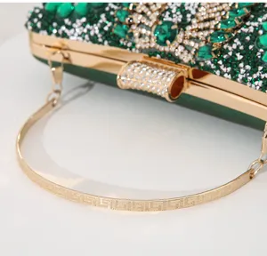 Detailaufnahme einer luxuriösen grünen Strass-Abendtasche mit elegantem goldenem Metallgriff