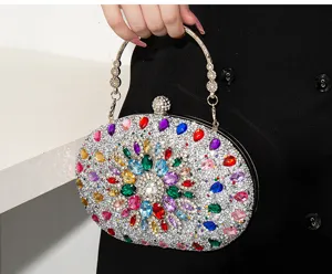 Gros plan d'une pochette de soirée scintillante avec des strass multicolores et anse argentée