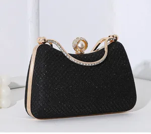 Detailansicht einer eleganten schwarzen Glitzer-Abendtasche mit Strassgriff und Perlenverschluss.