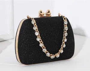 Detailansicht der schwarzen Glitzer-Abendtasche mit Herzverschluss und Strasskette