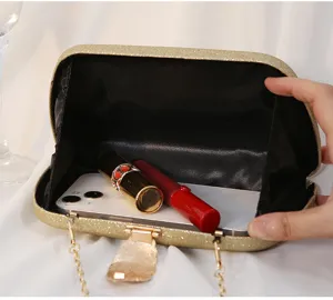 Detailed interior view of gold glitter evening clutch bag showing capacity for phone and lipsticks