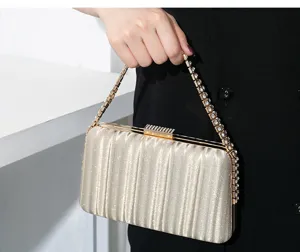 Elegante plissierte Abendtasche in Champagnergold mit Strassgriff und Verschluss.