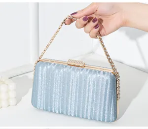 Detailansicht einer glitzernden blauen Abendtasche mit Diamantverschluss in der Hand