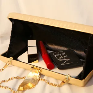 Elegante Abendtasche mit Metallblatt und Kette, zeigt das geräumige Innenvolumen.