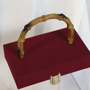 Elegante burgunderrote Samt-Geschenkbox mit Bambusgriff und goldenem Verschluss.