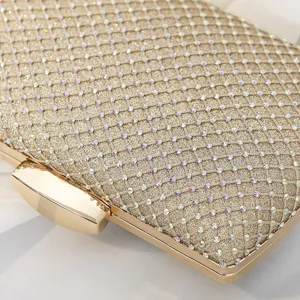 Close-up of gold sparkling clutch bag with rhinestone grid pattern and metal clasp