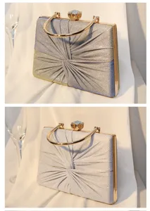 Detailansicht von schimmernden gefalteten Abendtaschen mit Goldgriffen und Kristallverschluss