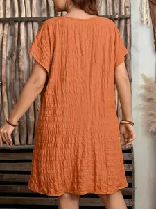 Back view of orange textured short sleeve mini dress featuring a crinkled fabric