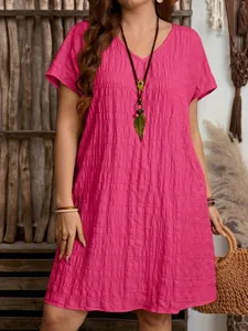 Detailed close-up of pink V-neck loose dress featuring unique crinkled fabric texture.