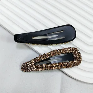 Vue détaillée de barrettes goutte avec strass champagne et base en métal noir de qualité