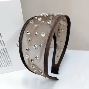 Nahaufnahme eines eleganten Netzstirnbands mit funkelnden Strasssteinen und Nieten