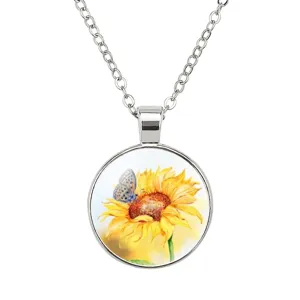 Gros plan d'un pendentif circulaire en verre avec motif de tournesol et de papillon