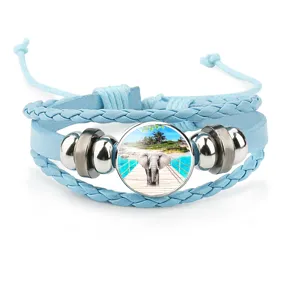 Detail view of a light blue multi-layer braided bracelet with a round elephant charm