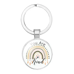 Detailed view of silver keychain pendant featuring a boho rainbow and 'You Are Kind' print