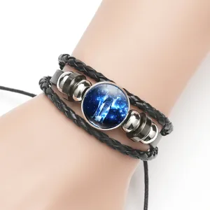 Detail shot of multi-layer black bracelet with a galaxy elephant glass dome charm.