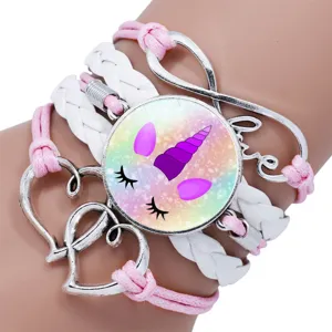 Close-up of multilayer unicorn bracelet with pink ropes and white braided leather cords.