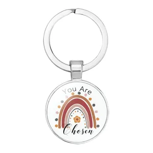 Detail of silver circular keychain featuring a boho rainbow and "You Are Chosen" text
