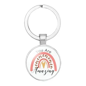 Close-up of circular silver-colored keychain with a rainbow and 'You Are Amazing' text